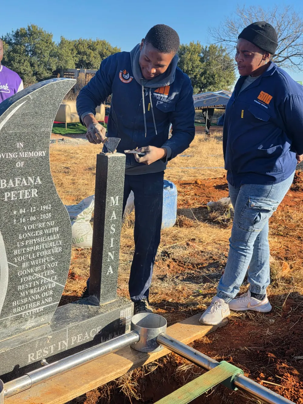 The SNC team finishing a granite headstone at the graveside