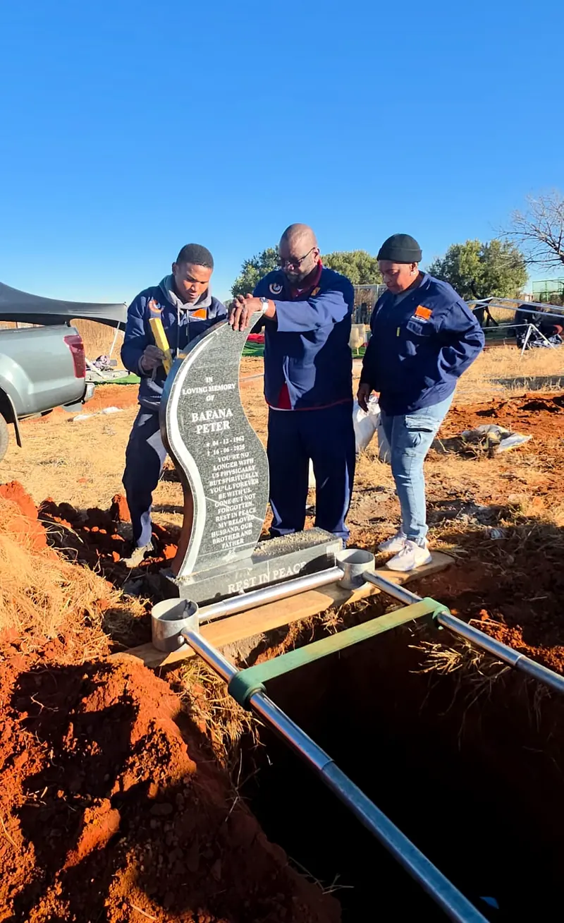 The SNC team installing a headstone at the graveside